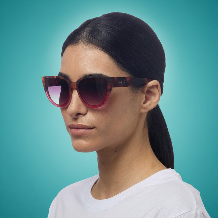 Woman wearing a pair of okkia sunglasses with a white background
