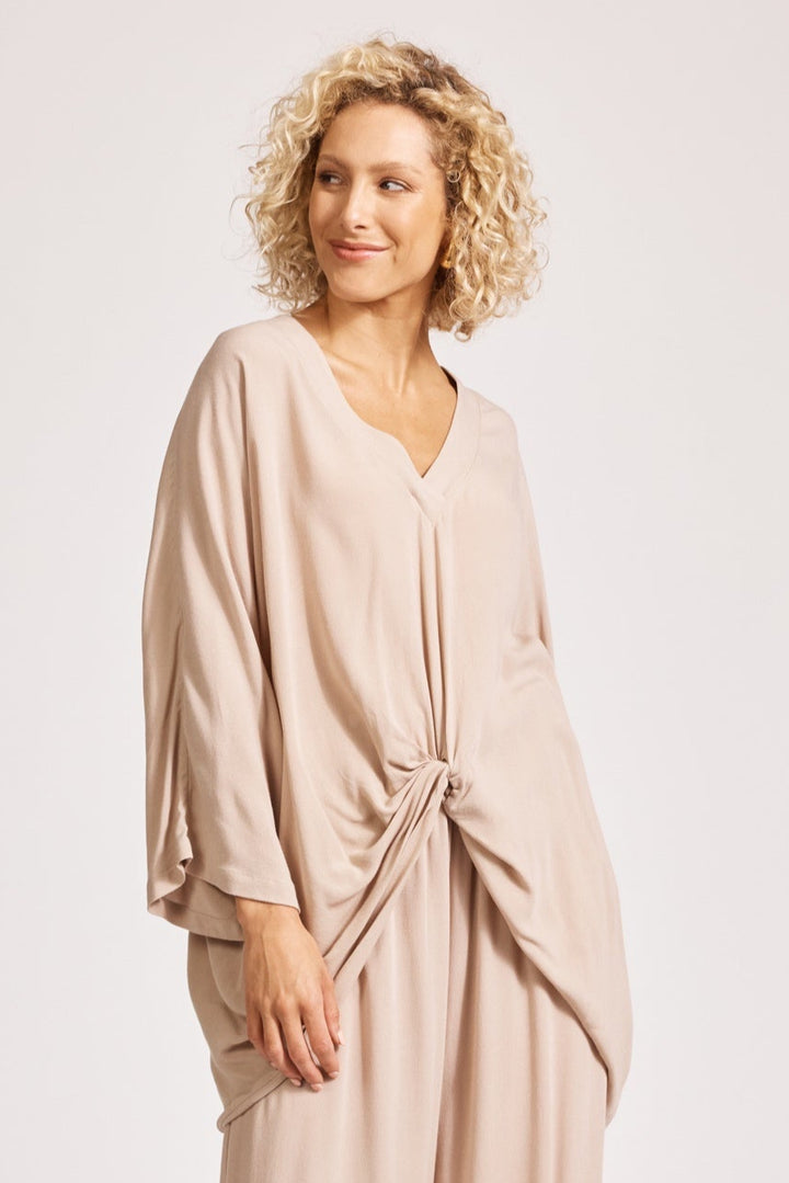 Woman wearing a beige outfit on a white background