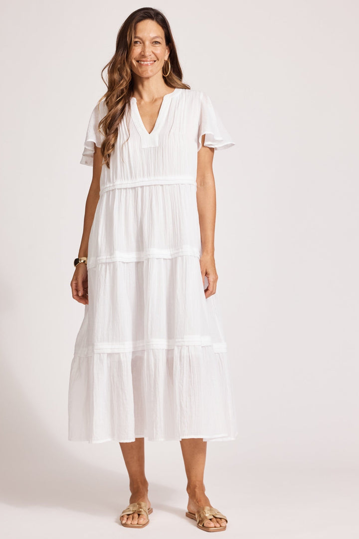 Woman wearing a white dress against a plain background