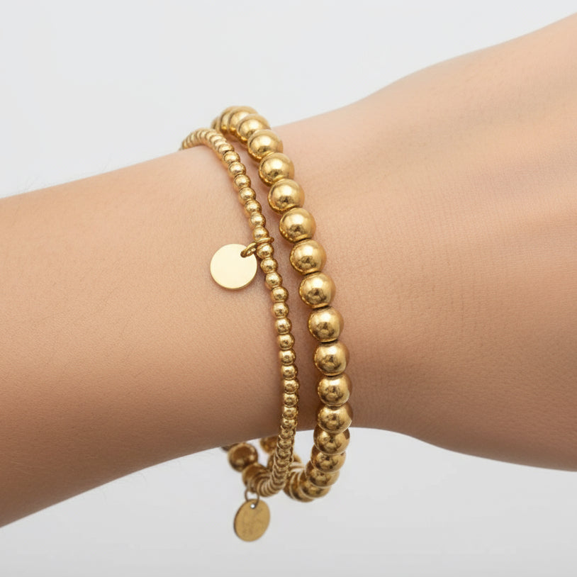 Gold beaded bracelet on a white background
