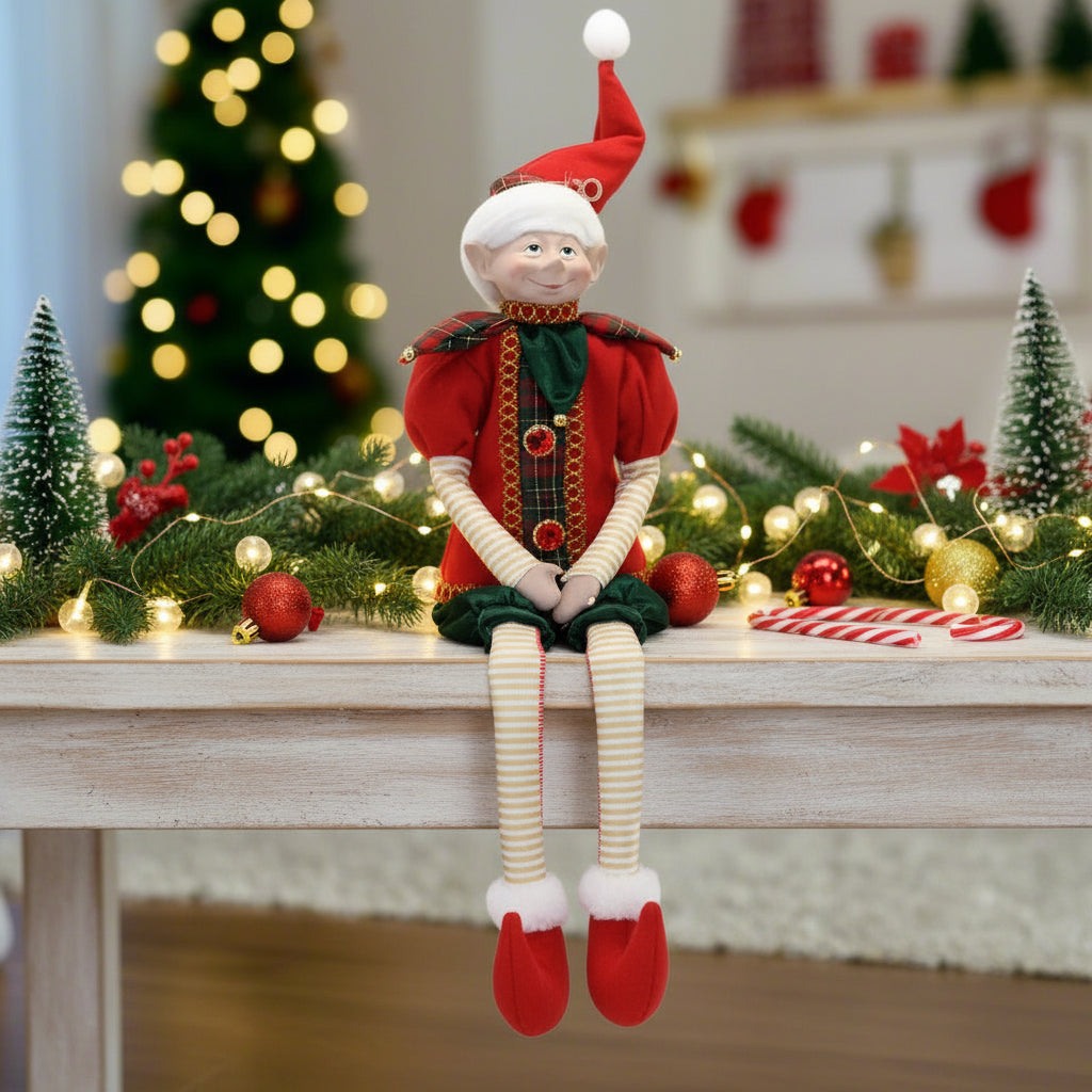 Christmas elf doll in red and green outfit on a white background