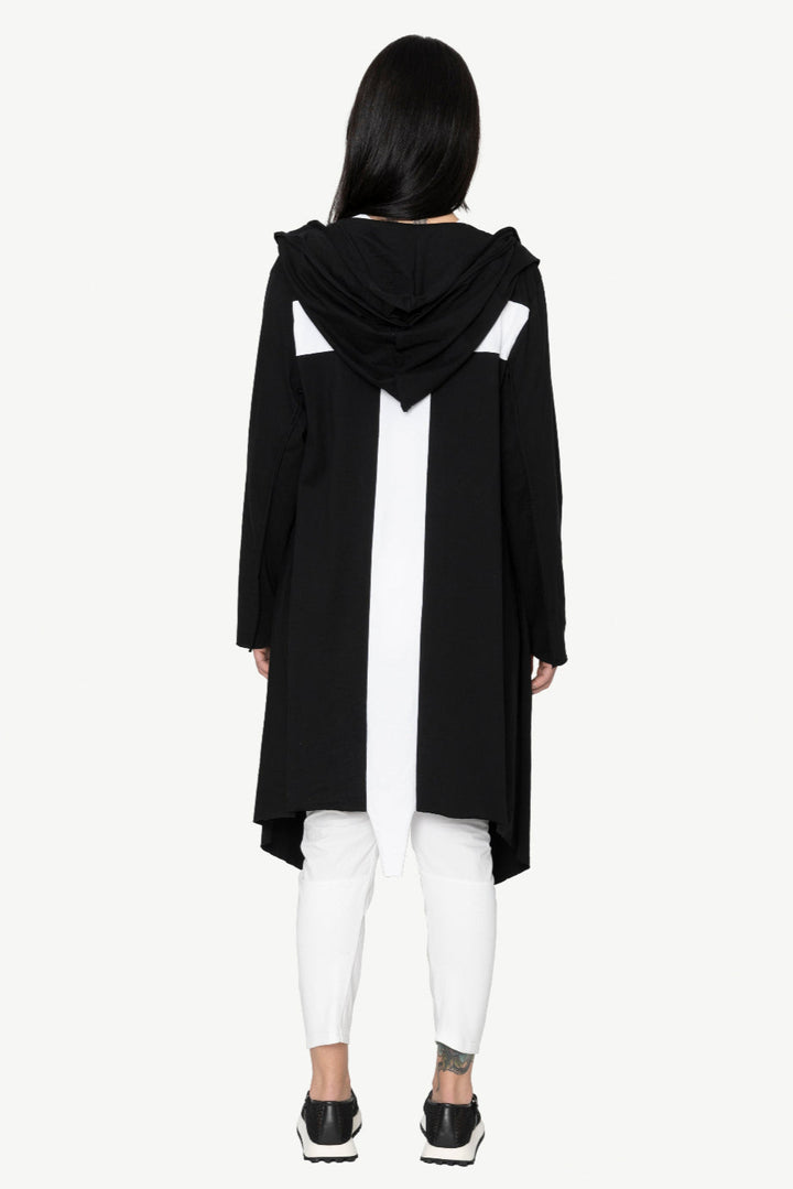 Person wearing a black hooded coat on a white background