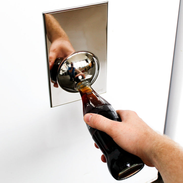 Hand using a bottle opener on a mirror surface
