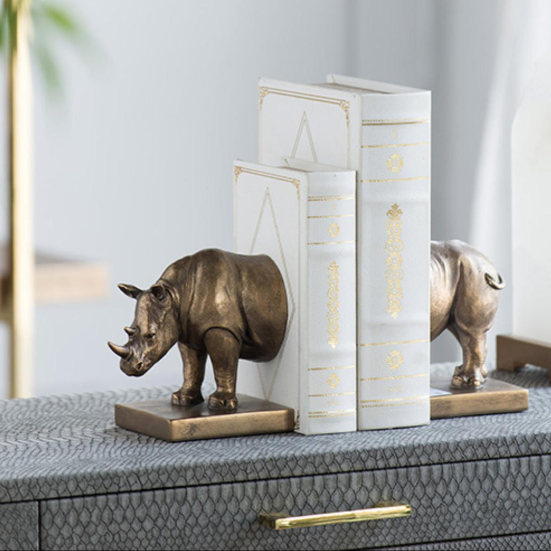 Bronze rhino bookends on a surface with a neutral background