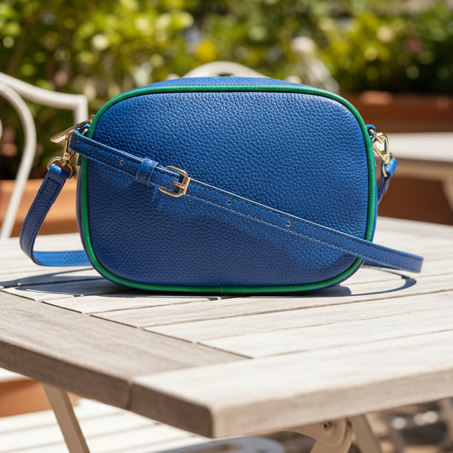 Blue crossbody bag with green accents on a white background