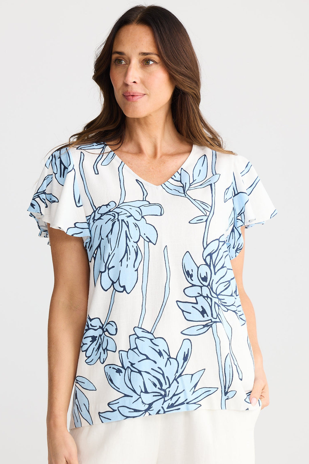 Woman wearing a blue floral patterned shirt on a white background