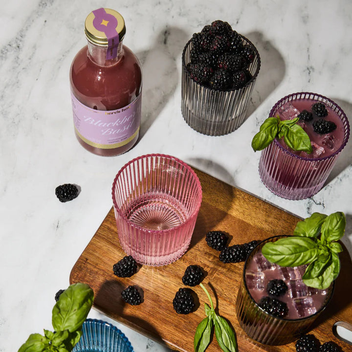 Drinks with blackberries and basil on a marble surface