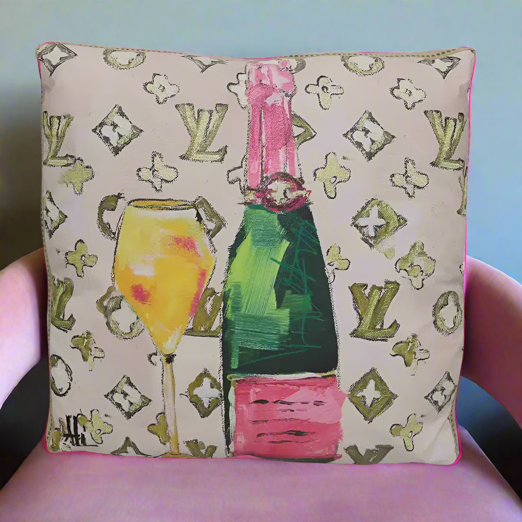 Decorative pillow with champagne bottle and glass design on a patterned background