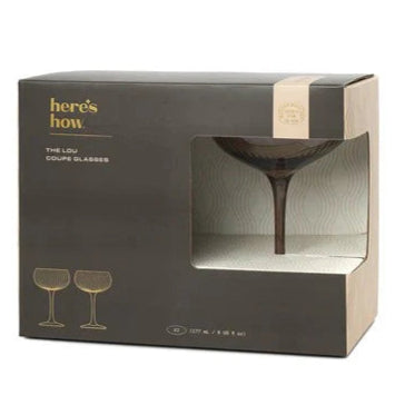 Boxed set of 'here's how' Lou Coupe Glasses with a gold accent on a white background