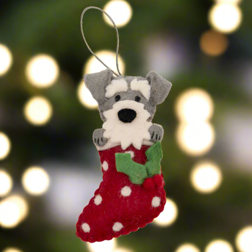 Felt dog in a red stocking with white polka dots on a white background