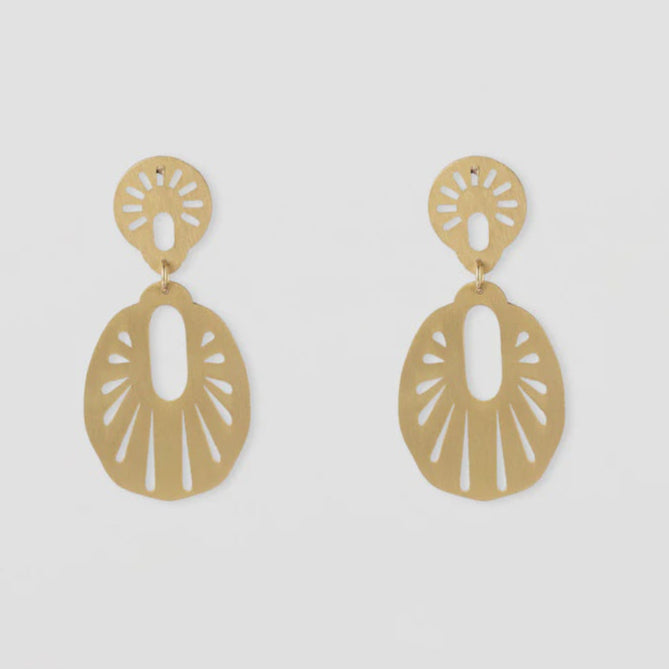 Gold earrings on a light gray background