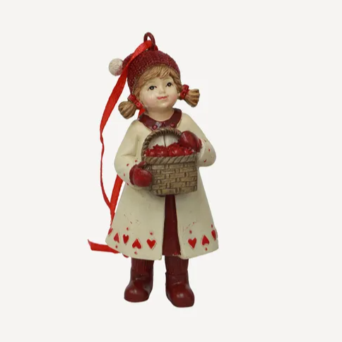 Decorative figurine of a girl in a white coat with red hearts, holding a basket, on a white background.