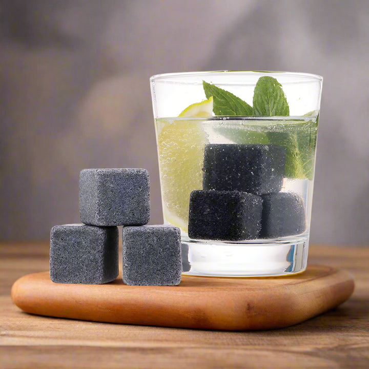 Set of gray stones next to a glass of water with lemon and mint on a white background