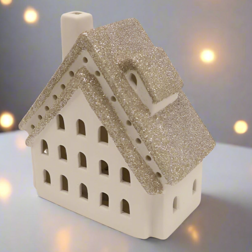 Decorative house-shaped lantern with glittery roof on a white background