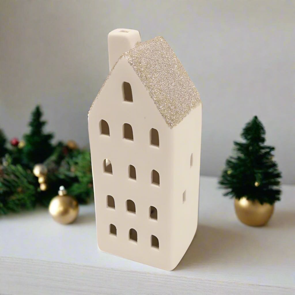 Ceramic house-shaped vase with a glittery roof on a white background