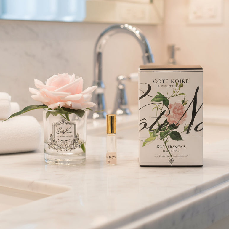 Cote Noire perfume bottle and packaging with a flower on a white background