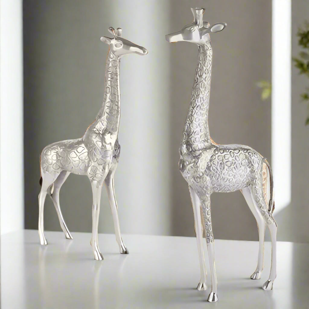 Two silver giraffe figurines on a white background