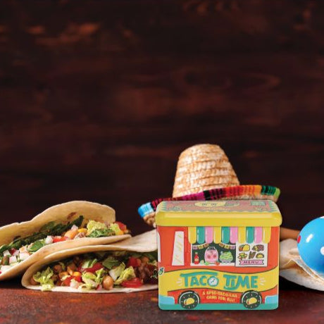 Colorful toy taco truck with two tacos on a wooden surface and dark background