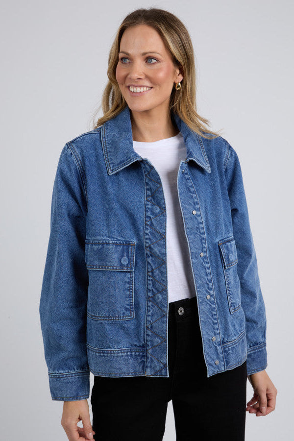 Woman wearing a blue denim jacket on a gray background
