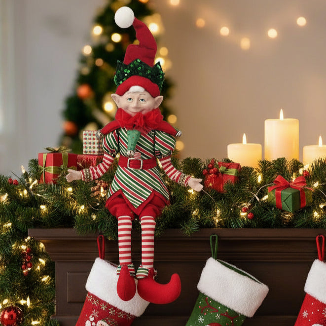 Christmas elf doll in red and green outfit on a white background