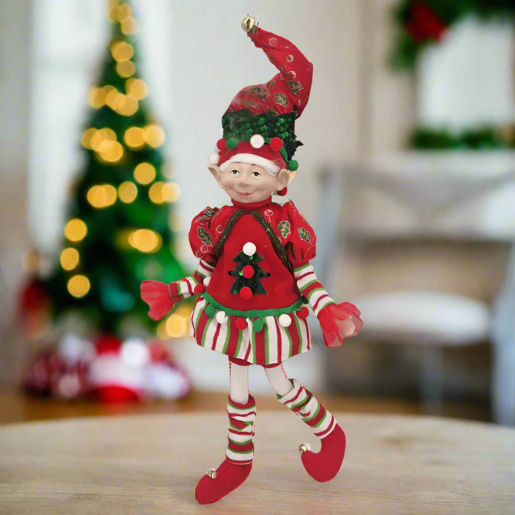 Christmas elf figurine in red and green outfit on a white background