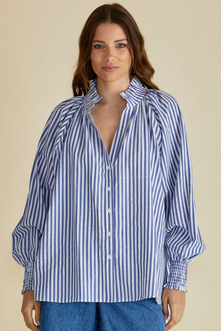 Woman wearing a blue and white striped betty basics shirt with a plain background