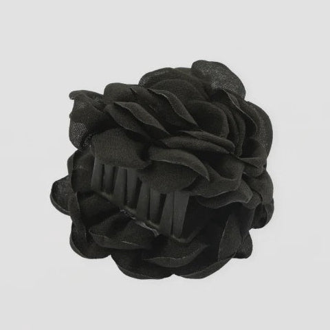 Black textured flower-shaped object on a light gray background