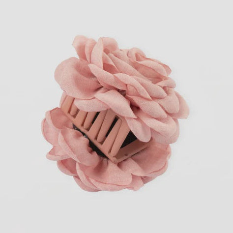 Pink hair clip with floral design on a light gray background