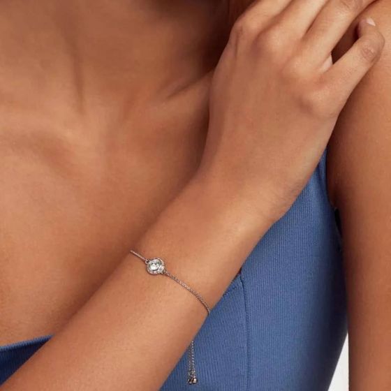 Close-up of a hand wearing a bracelet with a blue background