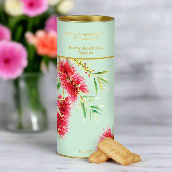 cylindrical packaging of Butter Shortbread Biscuits with floral design on a white background