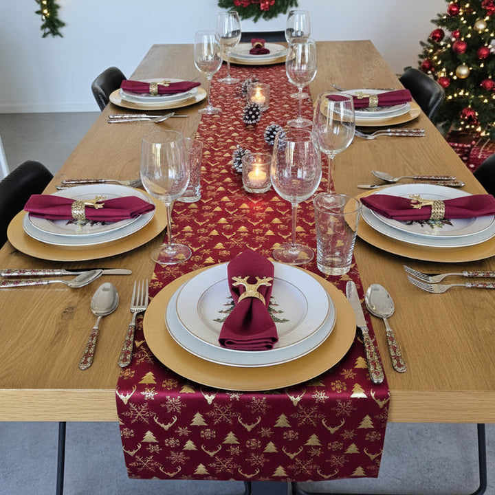 Red table runner with gold patterns on a wooden table in a room with chairs and shelves.