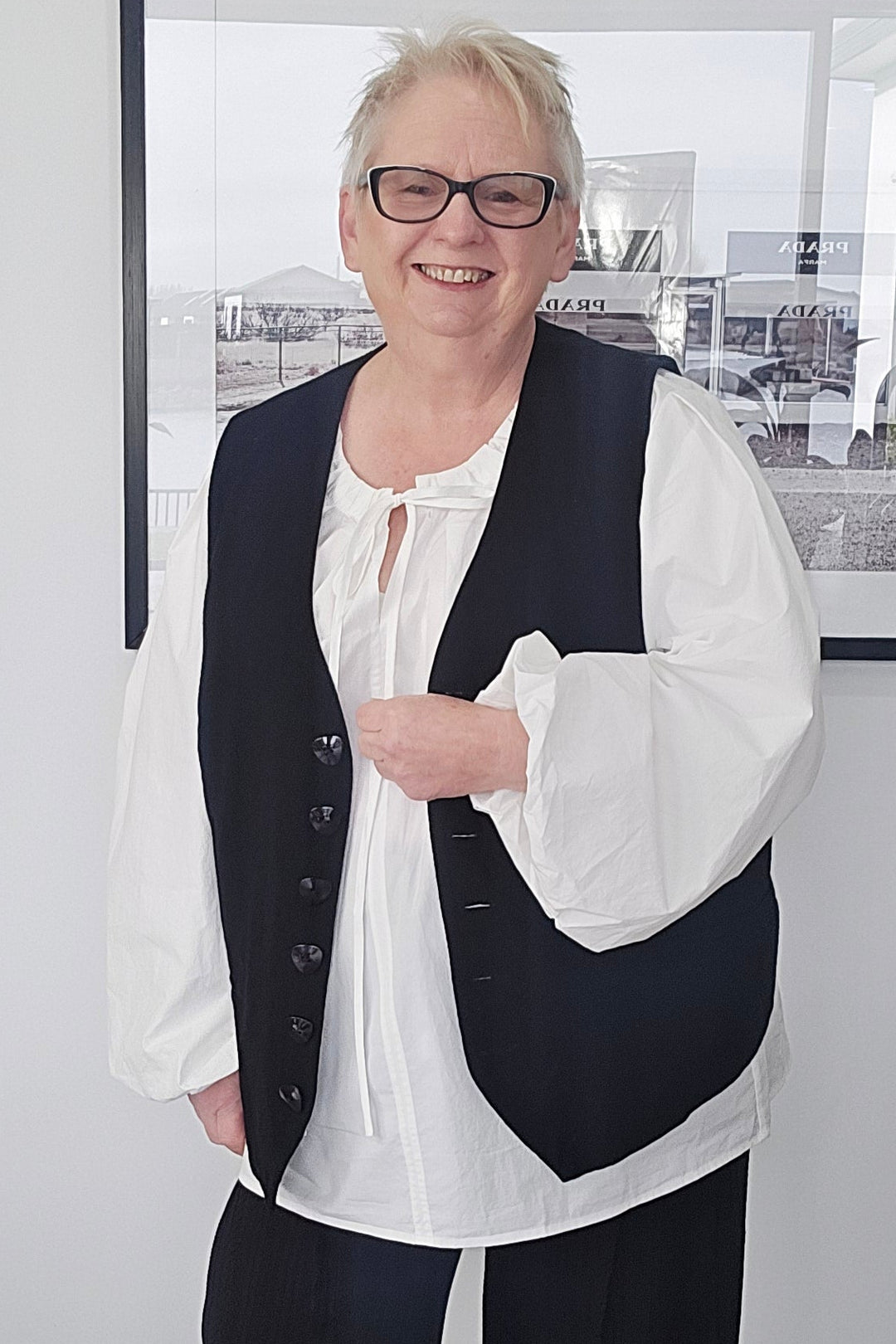 Person wearing a black and white outfit standing in front of a mirror.