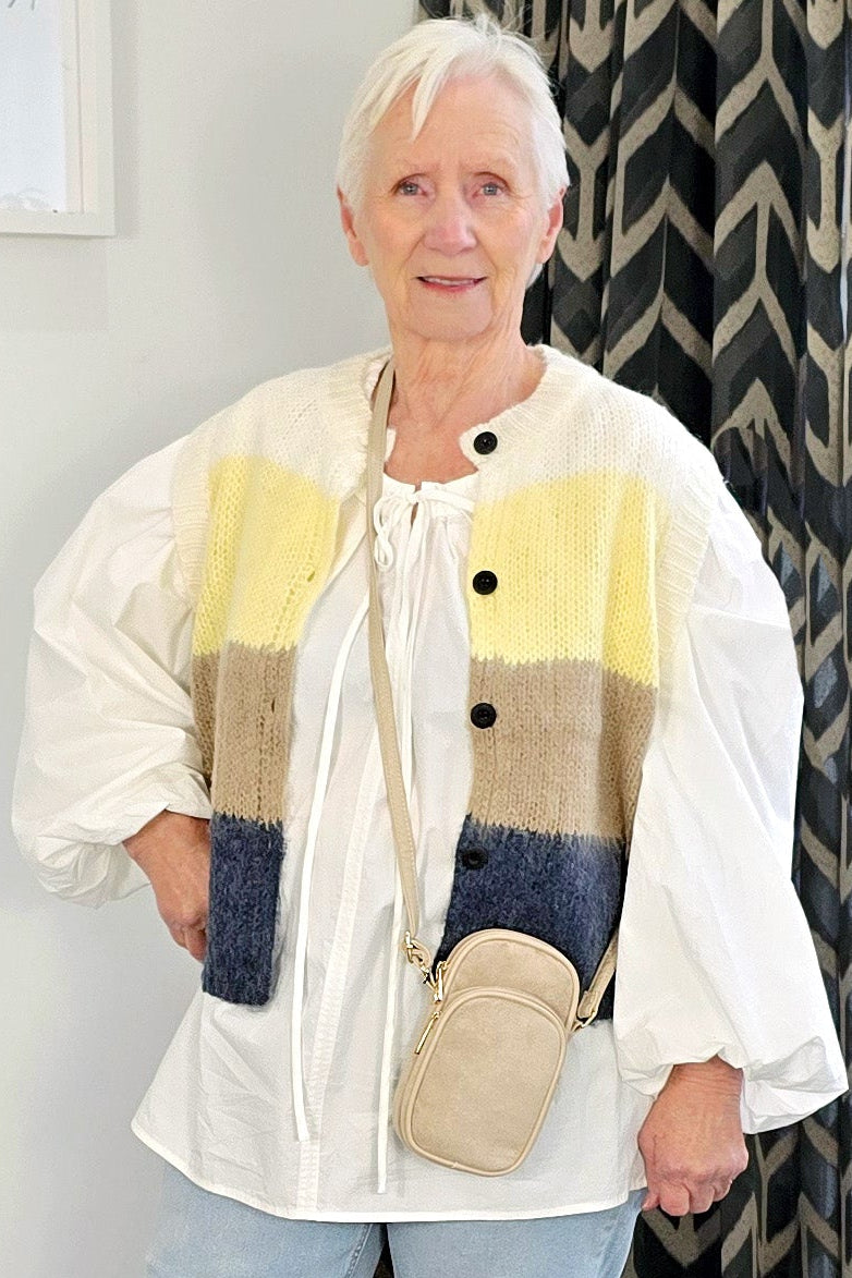 Woman wearing a colorful jacket with a neutral background