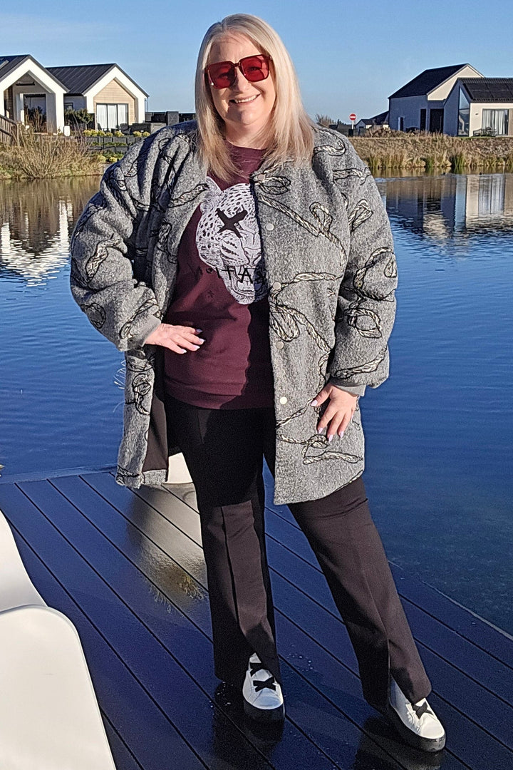 Woman standing on a dock by a body of water with houses in the background