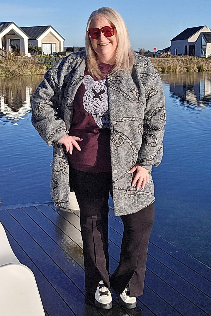 Person standing on a dock by a body of water with houses in the background