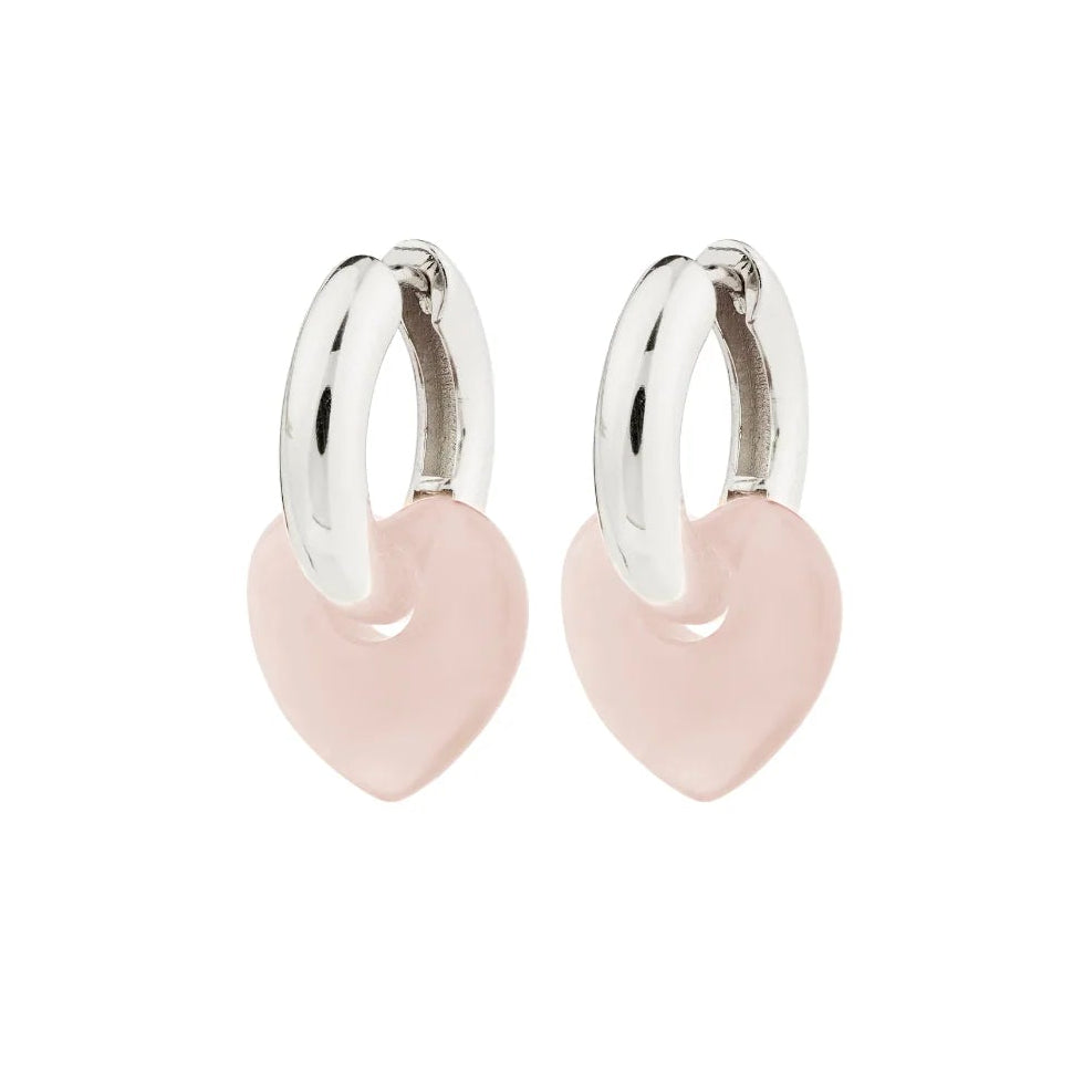 Pair of silver hoop earrings with pink heart charms on a white background