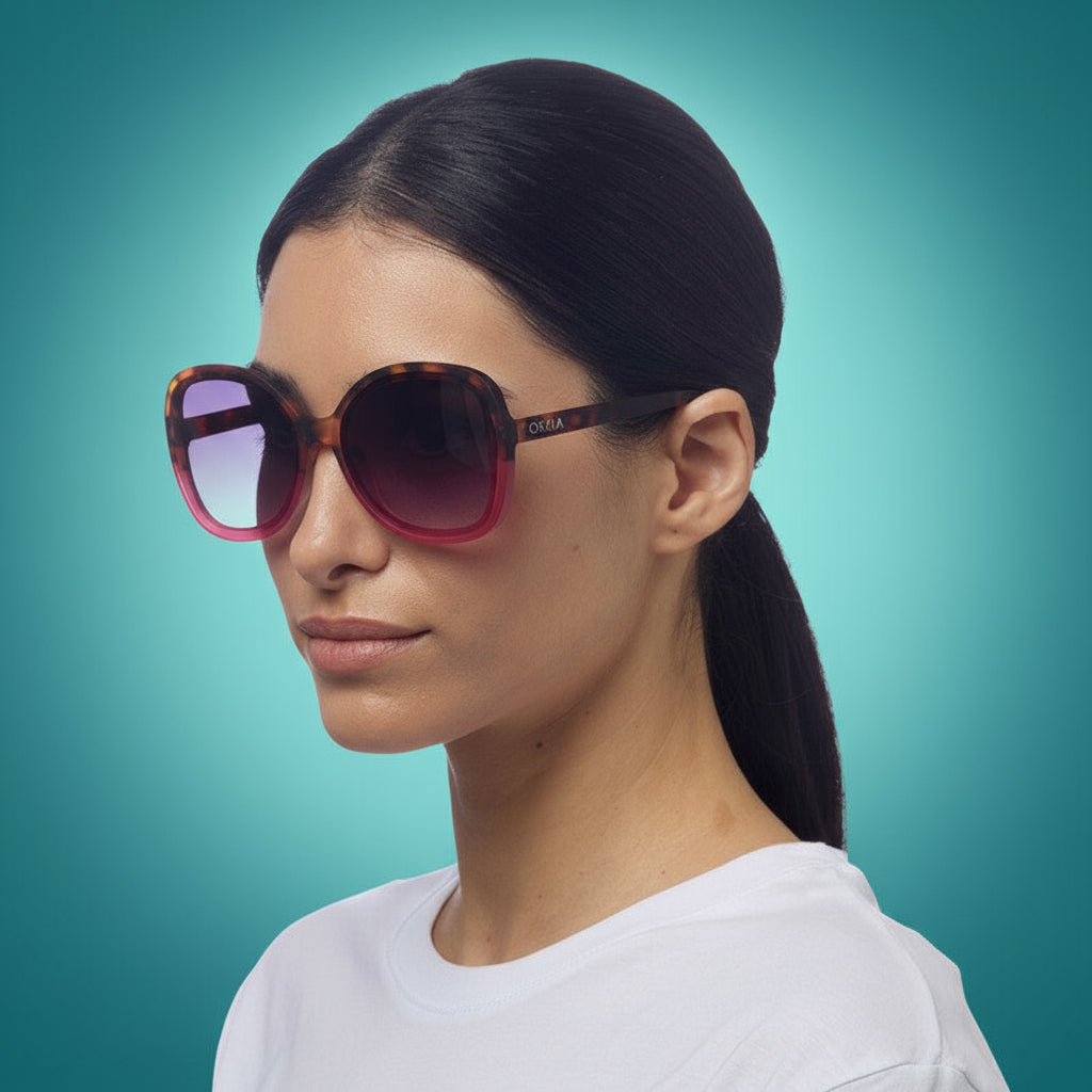 Woman wearing a pair of pink okkia sunglasses with a white background