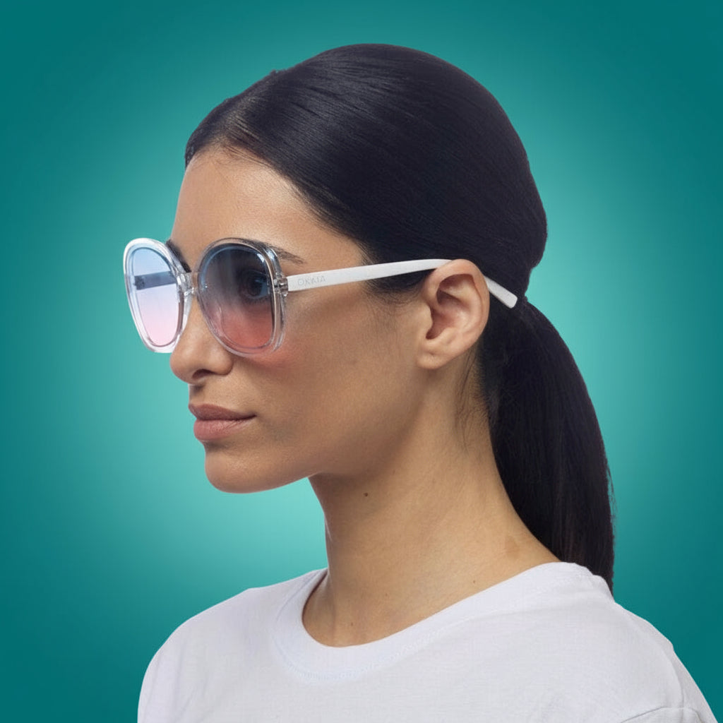 Woman wearing large okkia clear sunglasses with a white frame on a white background