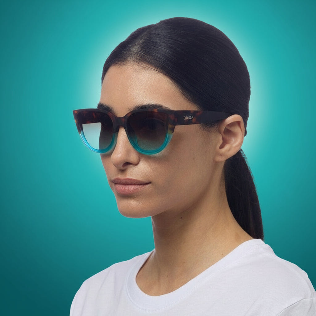 Woman wearing a pair of okkia sunglasses with a white background