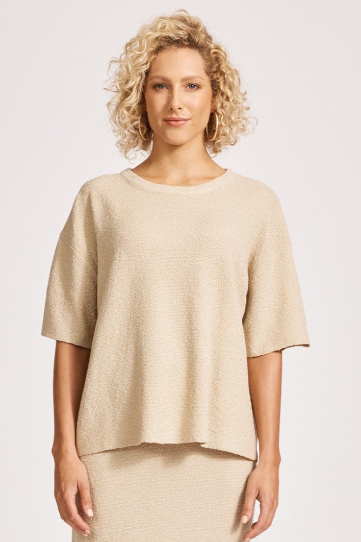 Woman wearing a beige outfit on a white background