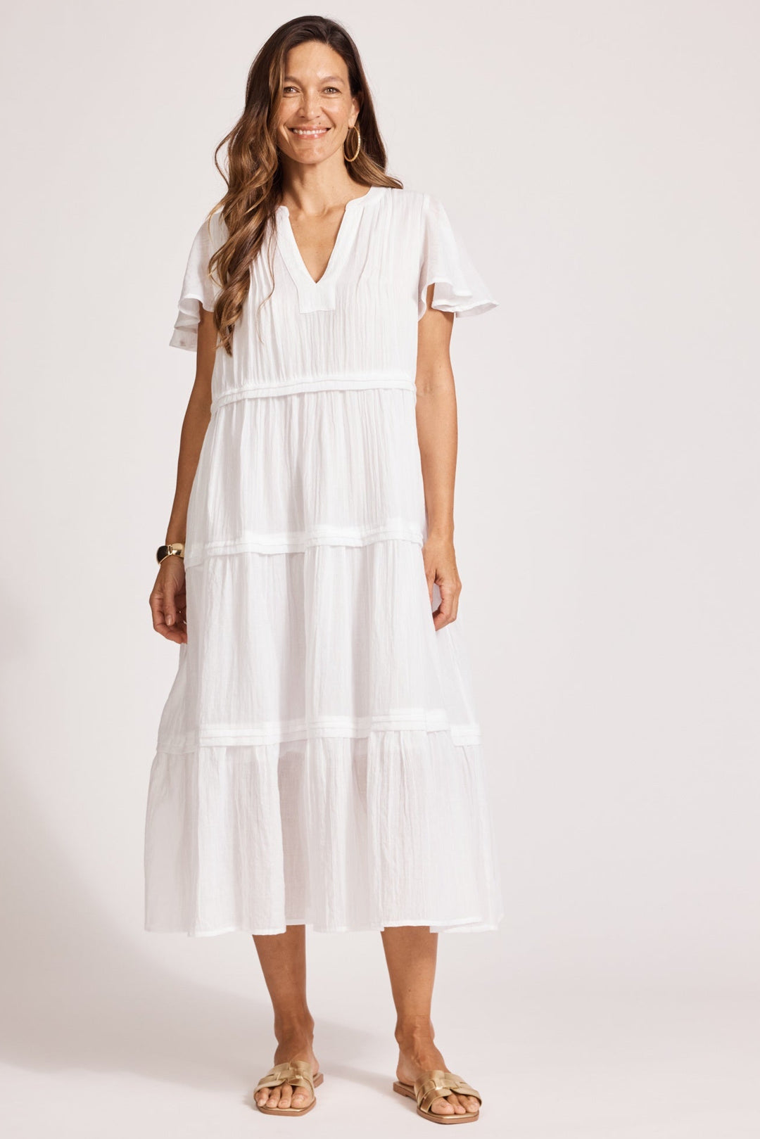 Woman wearing a white dress against a plain background