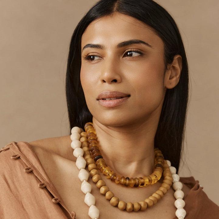 Woman wearing a necklace with a neutral background
