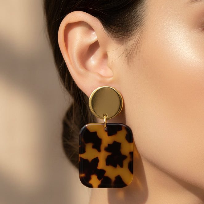 Tortoiseshell square earrings with gold posts on a white background