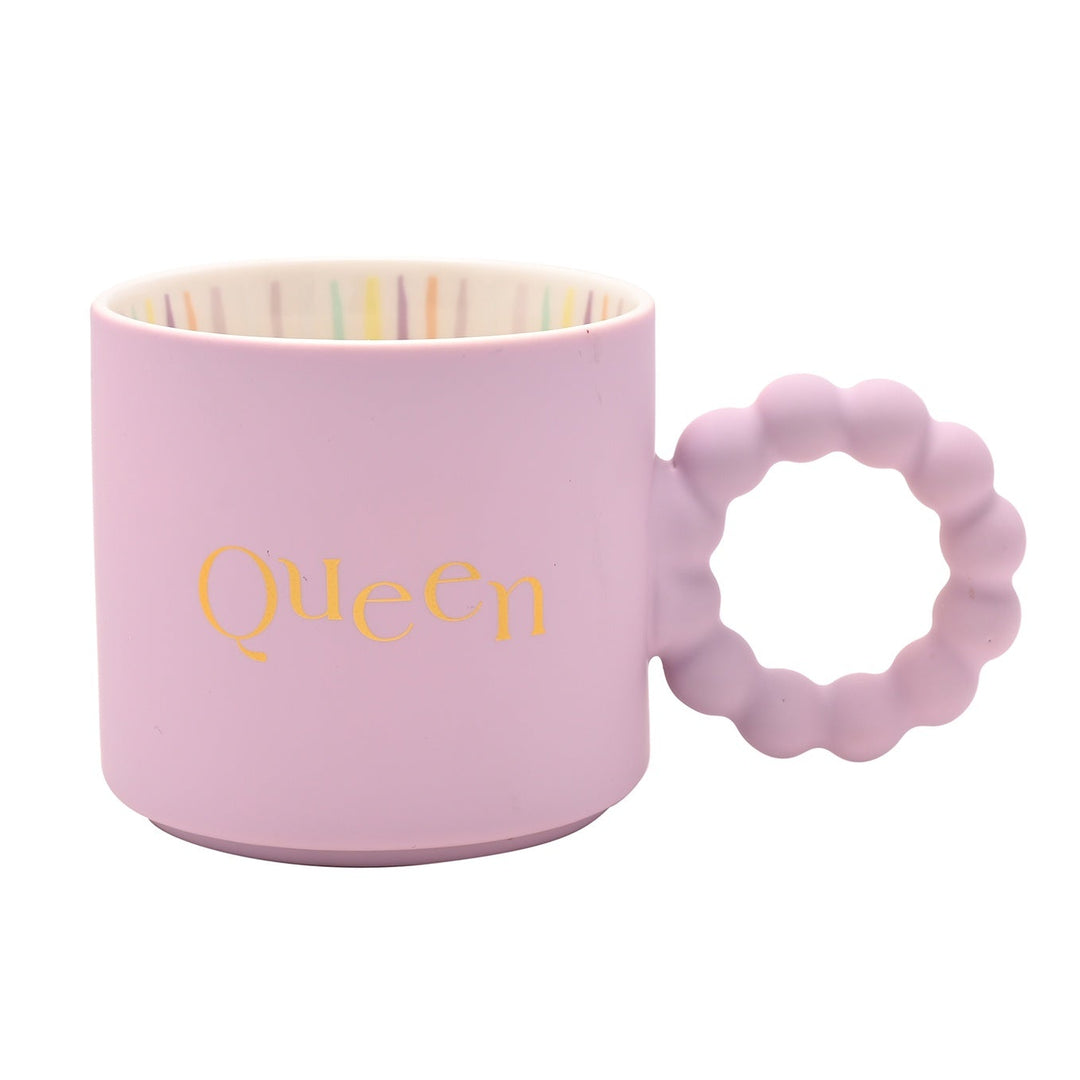 Pink mug with 'Queen' text and matching teething ring on a white background