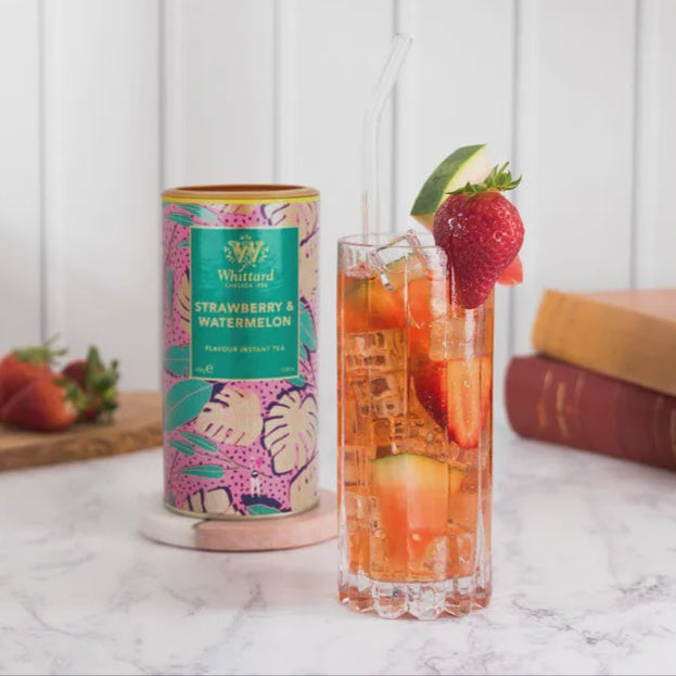 Strawberry watermelon iced tea with a can and books on a marble surface