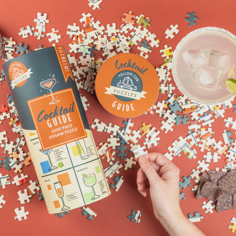 Cocktail-themed puzzle with pieces scattered on a red background, including a box, coaster, and drink.