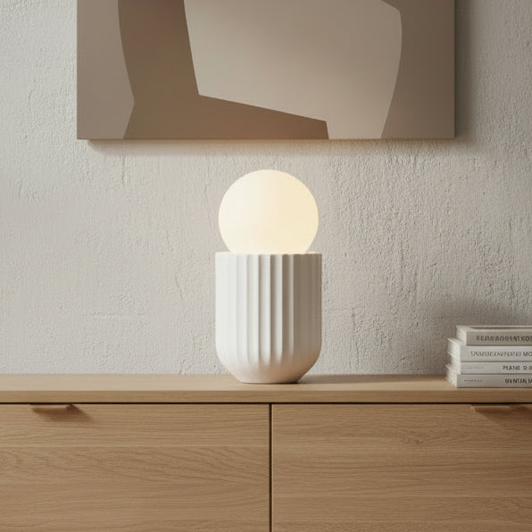 White textured lamp with a glowing yellow light bulb inside on a white background