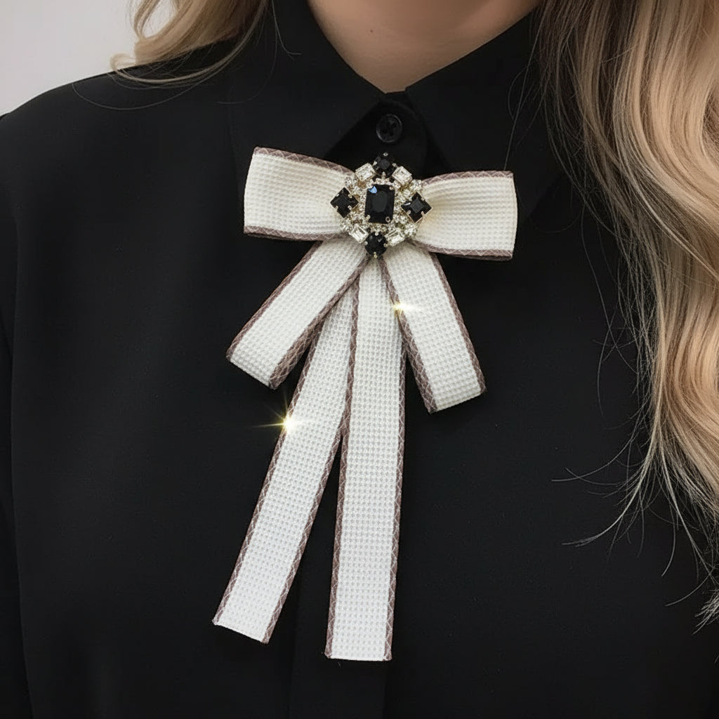 White bow with black accents held by a hand against an orange and gray background