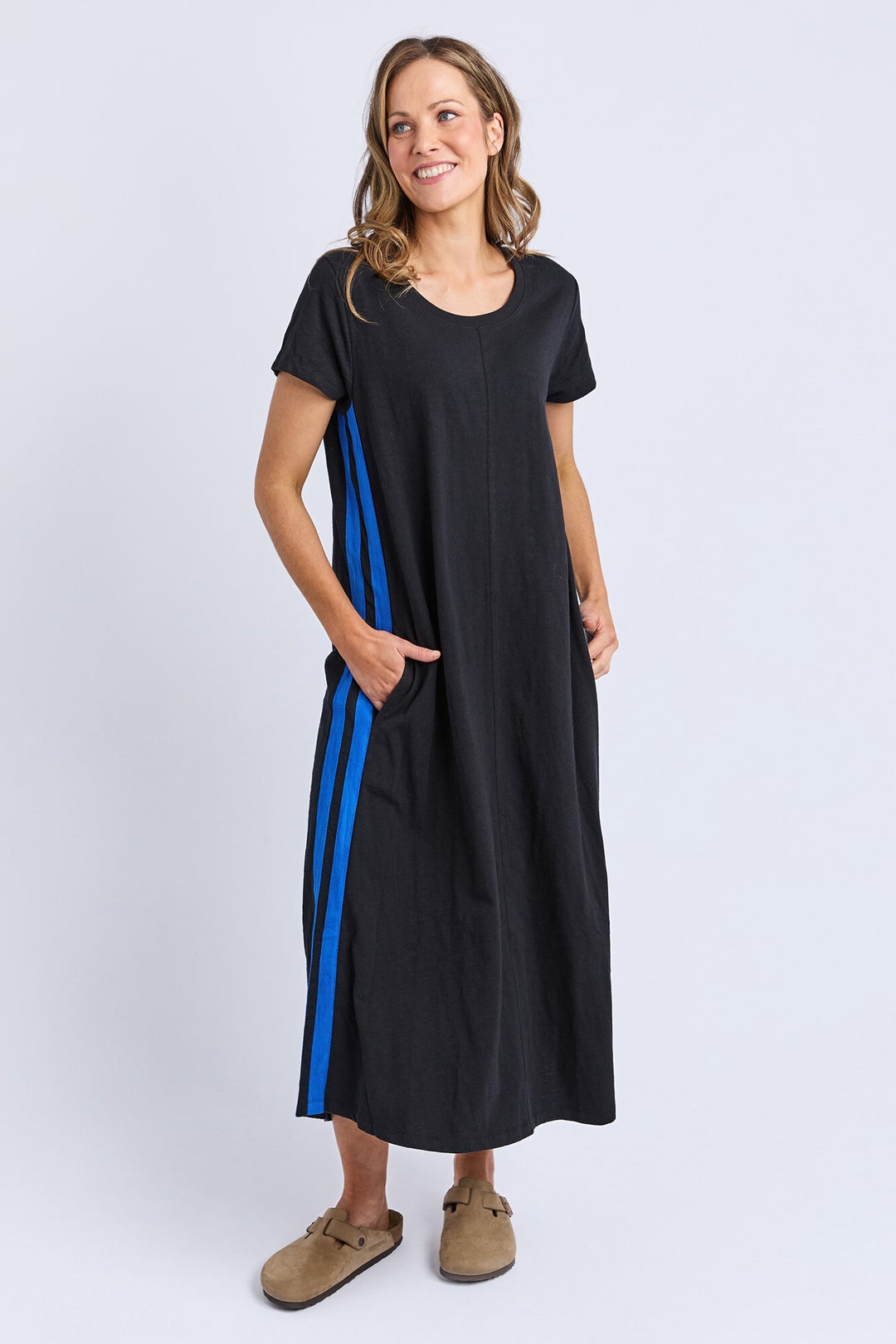 Woman wearing a black dress with blue stripes on a white background