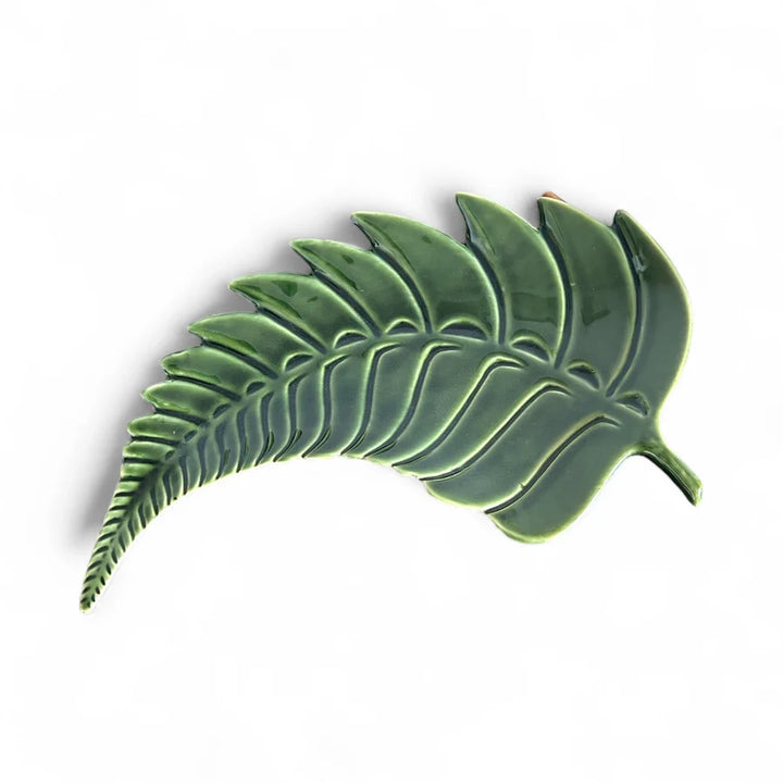 A glossy green ceramic leaf-shaped wall plaque or decorative piece, shown against a plain white background.